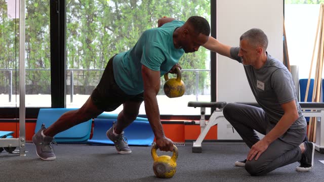 Sportsman doing kettlebell plank row exercise - Seahawk Workout routines