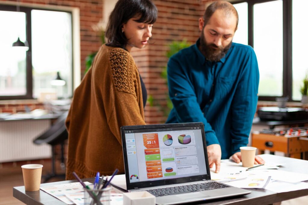businesspeople-analyzing-management-documents-discussing-company-strategy-while-brainstorming-ideas-business-project-startup-office-laptop-computer-with-marketing-data-chart-screen_482257-29679 - Seahawk B2B Web Design Agency
